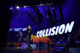 Tech conference stage with Collision sign