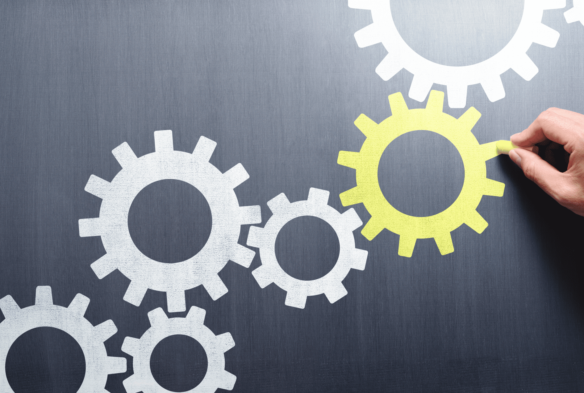 Interconnected white and yellow gears on a gray background.