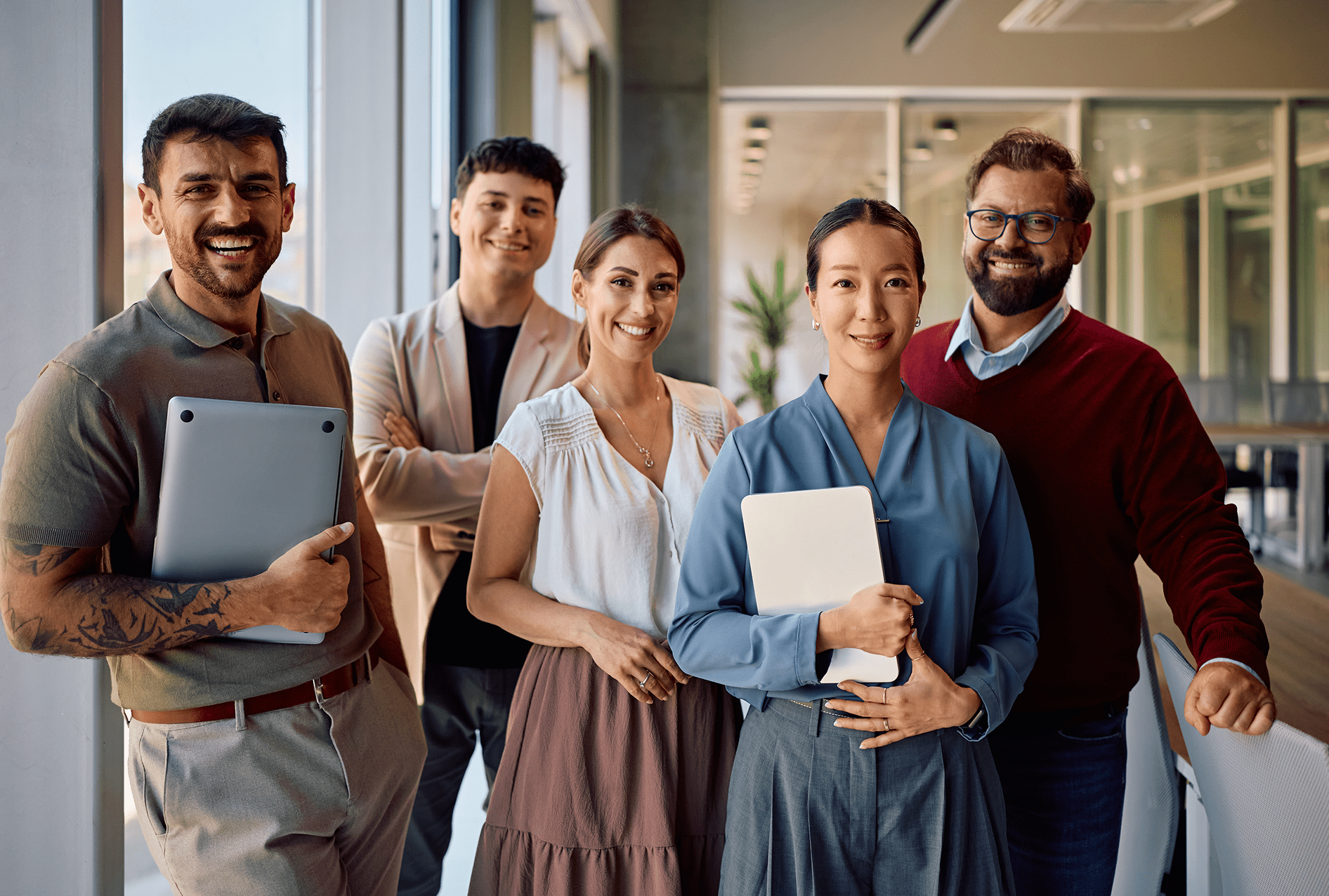 Diverse group of professionals smiling confidently indoors.