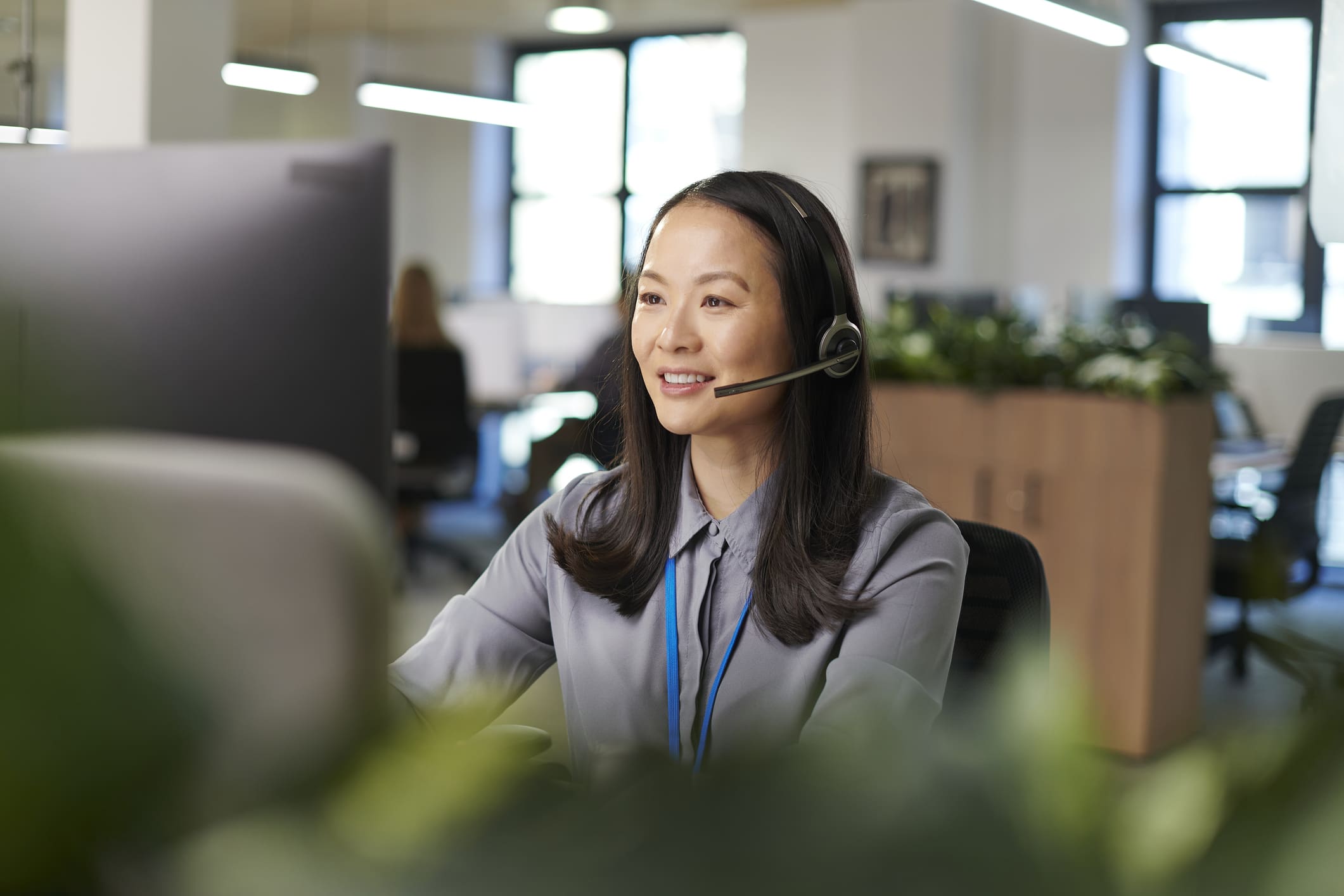 Customer service representative assisting a client with a headset.